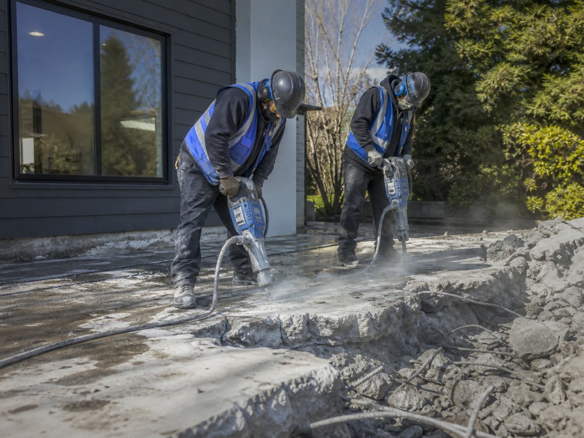 Old patio broken out by jackhammer with dust suppression running