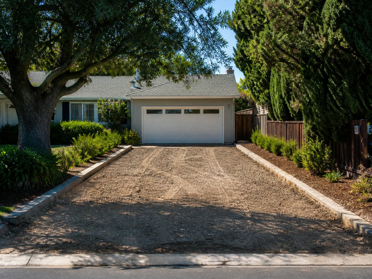 Clean graded driveway corridor running from street to garage