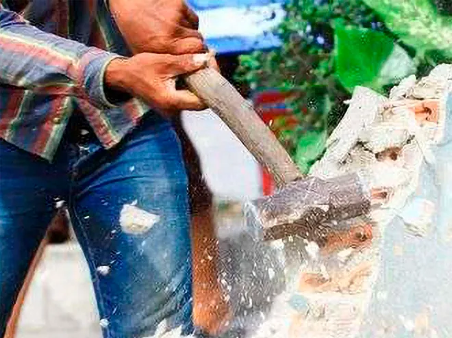 Hand demolition of an interior wall with a sledgehammer