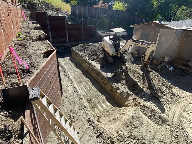Hillside excavation and cut beside a retaining wall