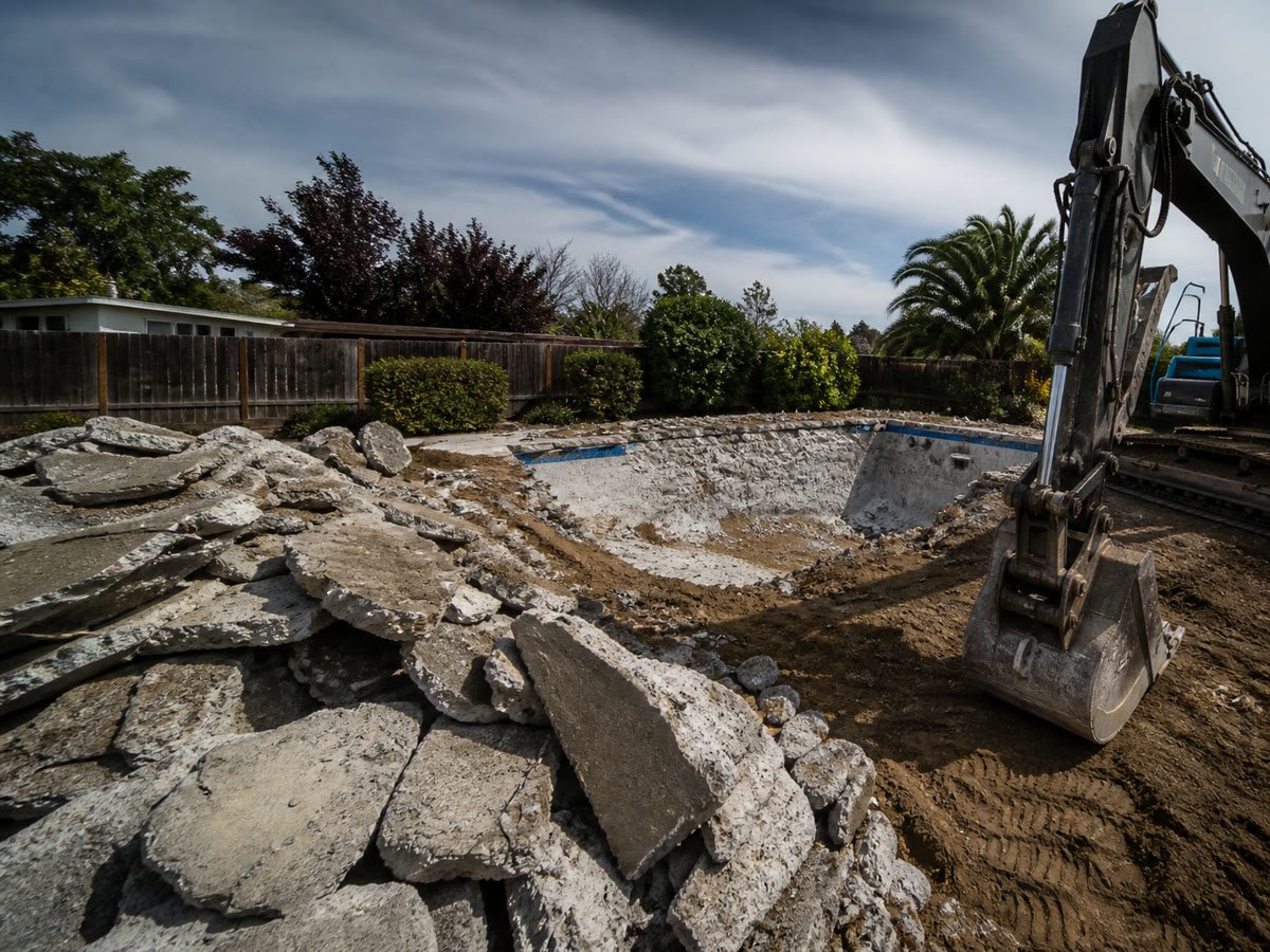 Broken pool shell and separated concrete ready for haul off