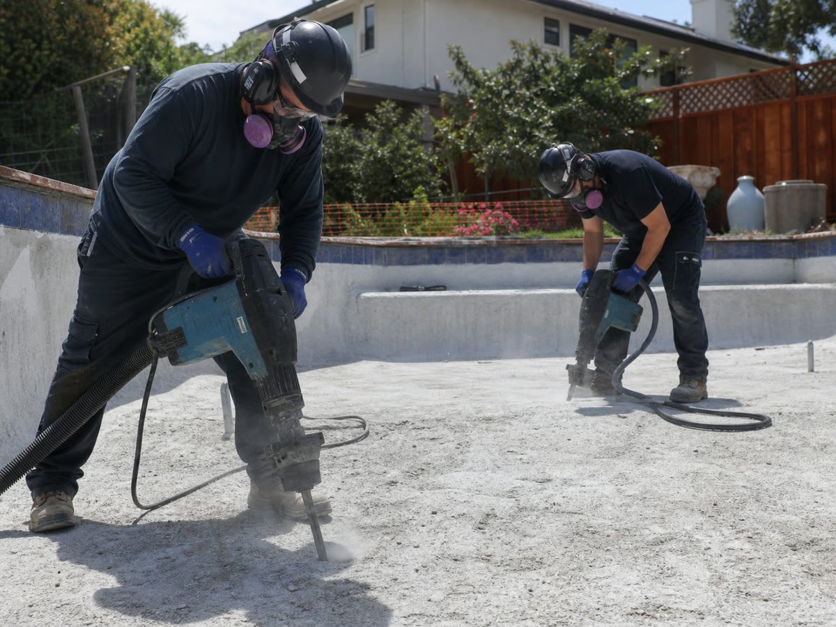 Drainage holes drilled in the pool bottom with dust control and PPE